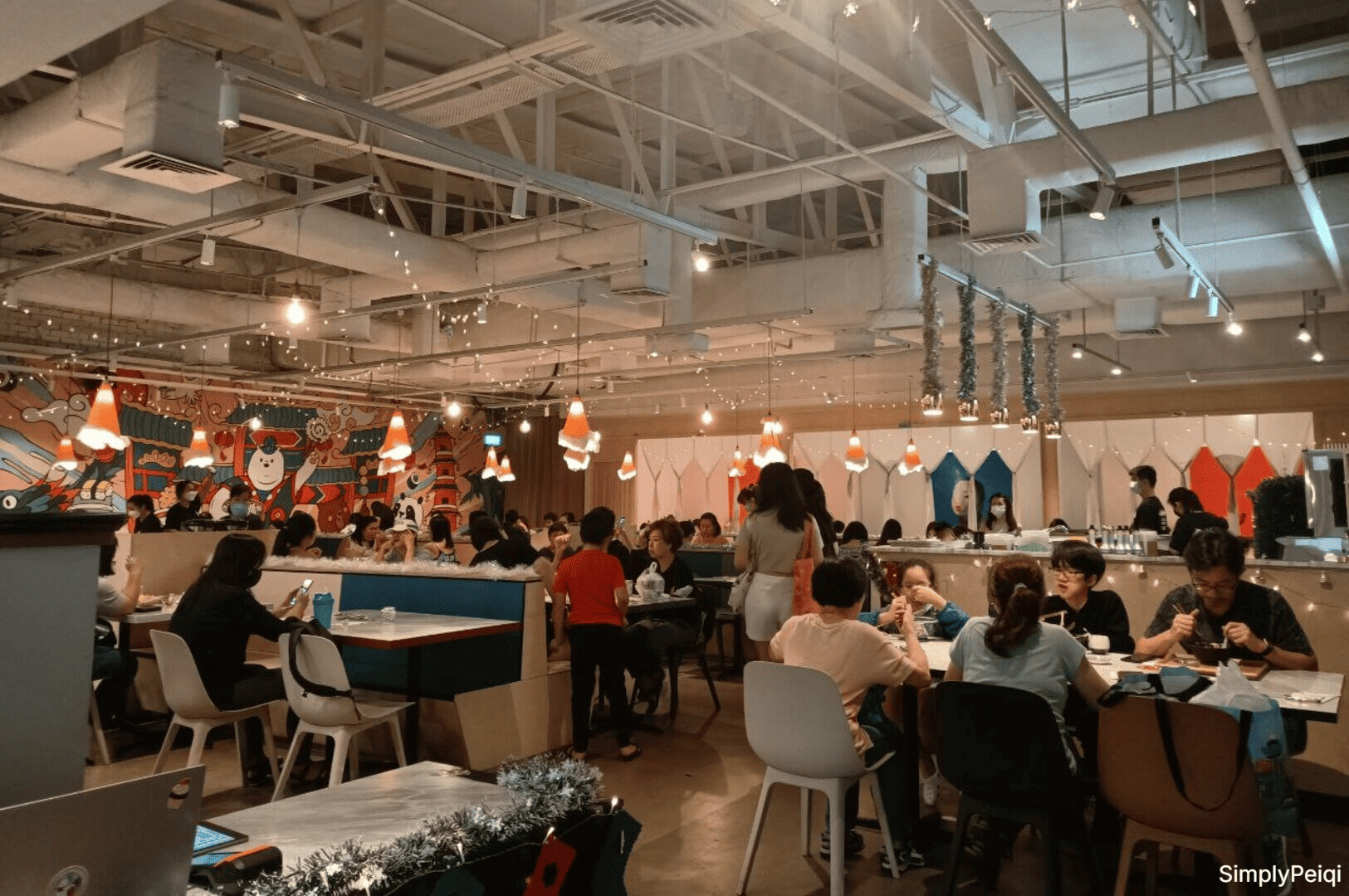 Diners savoring food and drinks in a lively atmosphere at Omote Thomson Plaza restaurant.