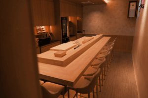 Interior view of a long bar with seating, highlighting options for omakase dining in Singapore beyond popular choices.